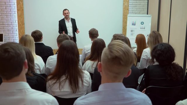 Person says about marketing and management to college students studying in classroom business people seminar audience conference meeting training coach speaker group seminar business team teamwork 4 K
