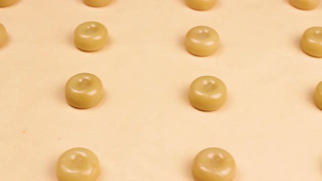 Sweet caramel candys on pastel yellow surface.