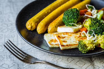 vegan dinner of vegetable sausages and vegetables