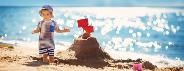 boy sitting smiling at the beach