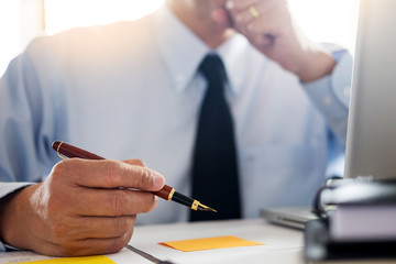 Business man working at office with laptop, tablet and graph data documents on his desk