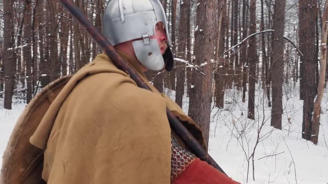 Medieval irish warriors in armor walking in a winter forest with spear and shield