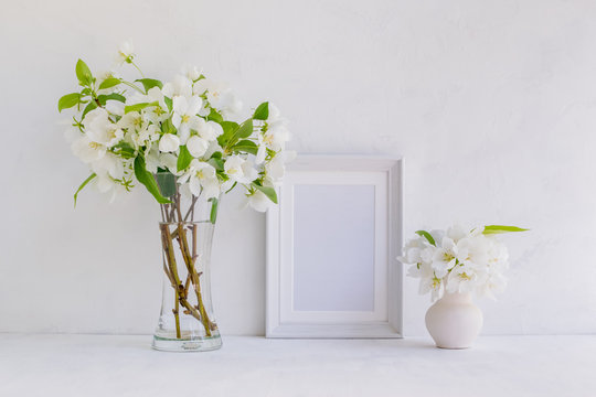 Mockup with a white frame and white spring flowers