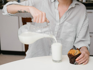 Fototapeta na wymiar Muffin with glass of milk on girl hands