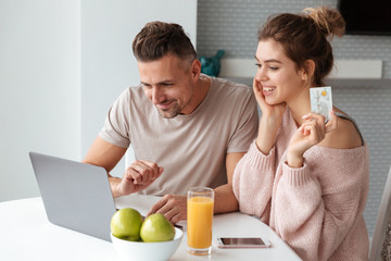 Portrait of a happy couple shopping online with laptop