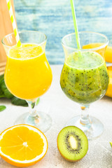 Tropical Healthy Smoothie with fresh kiwi, banana, watermelon and spinach on white against a blue wooden wall, top view. Diet, Detox, Healthy Dessert Concept