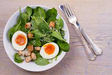Boiled egg with toasted bread, spinach and parmesan cheese for breakfast. Breakfast meal. View from above, top, horizontal