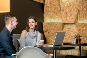 Young couple having fun at a caffe shop.