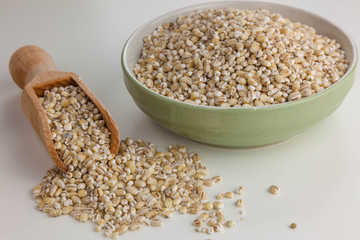 Pearl barley in the bowl isolated on the white background