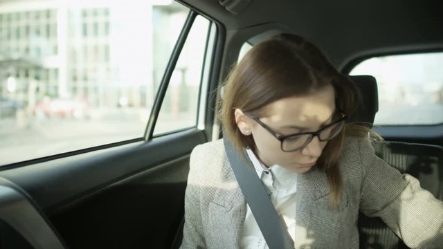 Businesswoman Fastening the Seat Belt and Checking Hour