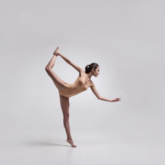 Fototapeta premium young beautiful dancer in beige swimsuit