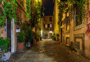 Fototapeta na wymiar Night view of old cozy street in Trastevere in Rome, Italy