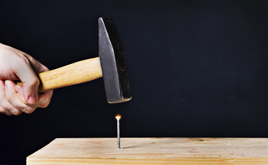 hammer a screw on a black background