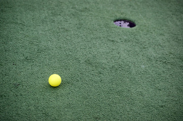 Golf ball near hole (Мяч для гольфа около лунки)