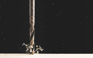 drilling a tree with flying chips on a black background