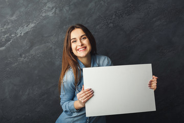 Young woman holding blank white banner