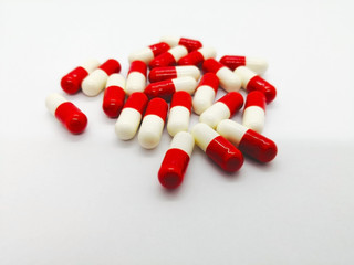 Medication concept. Many red-white capsules of Glucosamine 250 mg. isolated on white background, that is sugar protein that helps your body build cartilage. Selective focus and copy space.