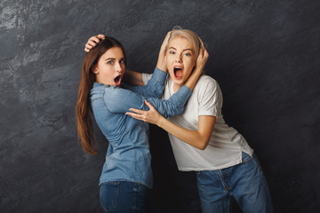 Two female friends having fun at studio background