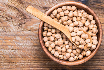 Chickpea in bowl top view on wooden rustic background text space.
