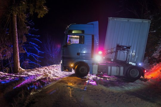 A Real Accident. Truck Traffic Accident At Night, On A Snowy Winter Road. Broken Truck On The Road In The Snow.