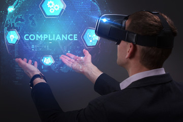 Business, Technology, Internet and network concept. Young businessman working on a virtual screen of the future and sees the inscription: Compliance