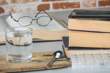 Pills box for week and separate the time with medicine in plastic box on table