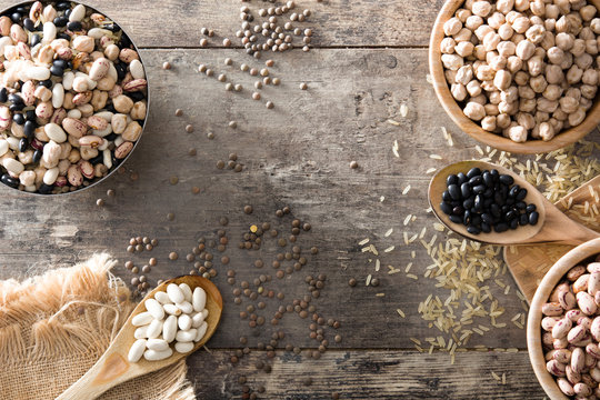 Uncooked assorted legumes in wooden bowl .Top view copy space on wooden table