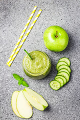 Fresh detox cucumber green apple smoothie in a glass on concrete background. Top view, space for text.