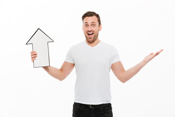 Emotional happy young man holding arrow while looking camera.