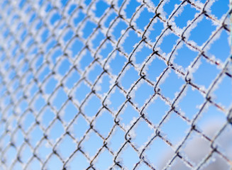 metal grill winter frosty morning on a blue sky background covered with snow
