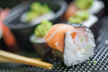 Fresh and delicious maki and nigiri sushi rolls with tiger shrimps, salmon, philadelphia cheese, rice and wasabi. Sushi menu. Japanese food in fancy restaurant. 