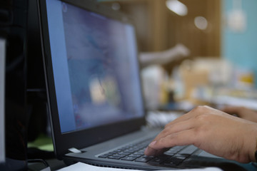 Man hand typing on laptop keyboard in office room, close up, business computer concept