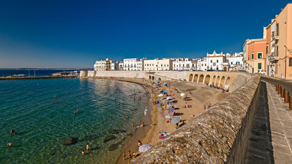Bagers sunbathe in the beach of purity, in the historic center of Gallipoli.