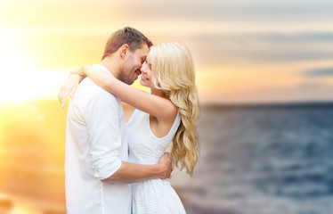 happy couple hugging and kissing on summer beach