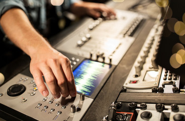 man using mixing console in music recording studio