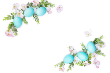 Spring Easter border composition. Turquoise eggs and green plant isoleted on white background. Blooming flowers. Copy space for text