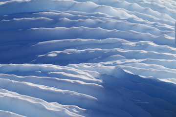 fałdy ze śniegu w odcieniu białym i niebieskim oświetlone niskim słońcem - obrazy, fototapety, plakaty