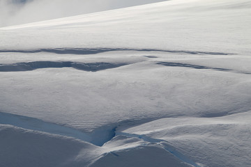 obsuwające się odłamane fragmenty śniegu i lodu na zboczu górskim
