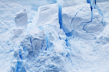 błękitne pęknięcia w górze lodowej o  mocno poszarpanej strukturze w zbliżeniu