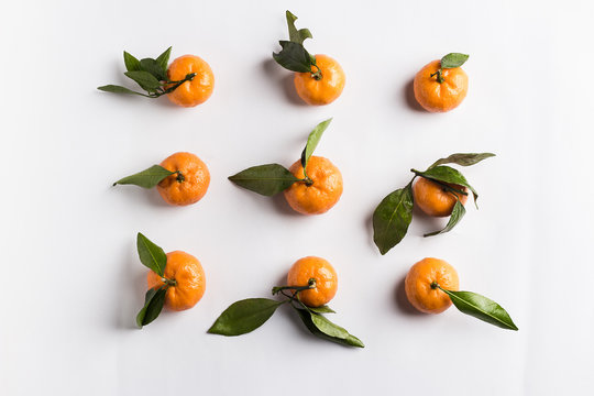 Tangerines isolated with green leaves on white background