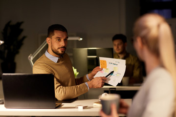 colleagues discussing project late in office