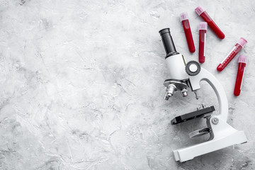 Blood test concept. Blood samples near microscope on grey background top view copy space © 9dreamstudio