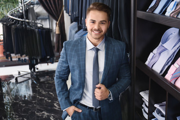 Handsome young man wearing suit in shop