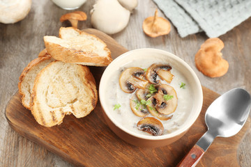 Bowl with mushroom soup on wooden board