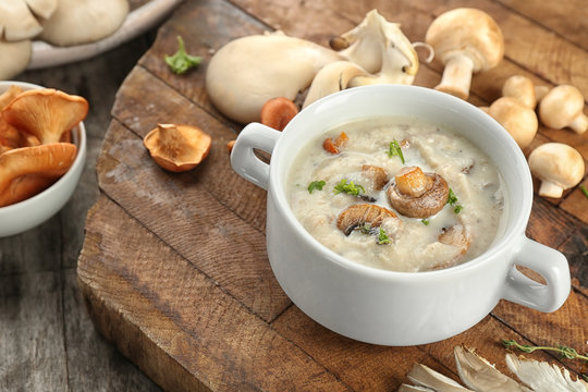Dish with mushroom soup on wooden board