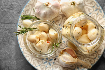 Preserved garlic in glassware on table