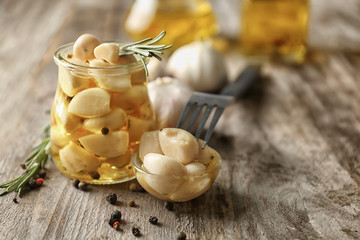 Preserved garlic in glassware on table
