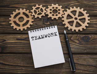 concept teamwork text on a notepad, gears piled puzzle. Business idea, cooperation, strategy.