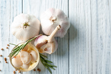 Preserved garlic in glass bowl on table