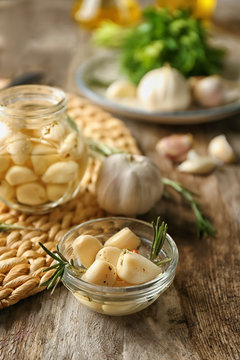 Preserved garlic in glass bowl on table
